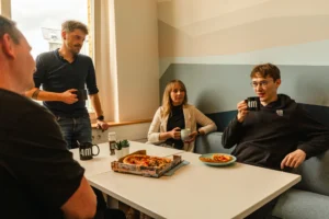 4M-Kollegen essen Pizza in der Mittagspause