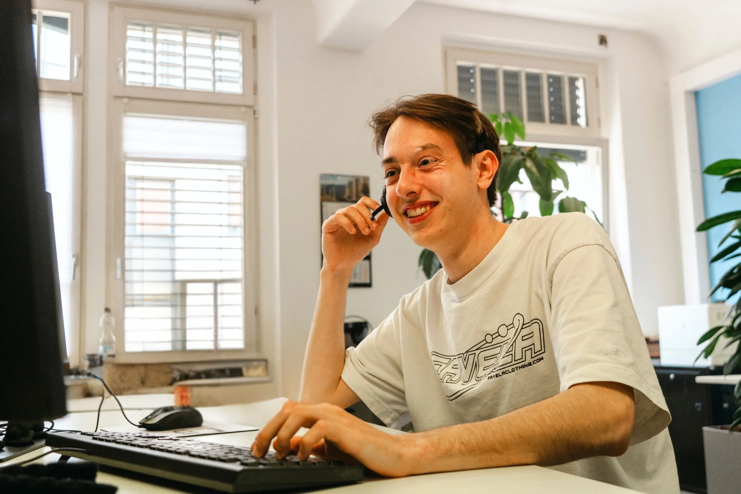 4M-Mitarbeiter mit Headset am Schreibtisch